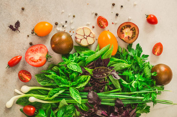 Fresh spinach,green onion, basil, herbs, dill and tomatoes on gray concrete background, selective focus. Top view. Toned effect. Food cooking ingredients. Vegan, raw, detox concept