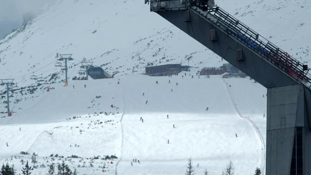Close-up view of slope on the skiing resort. Skiers enjoying snowy slopes in high mountains.