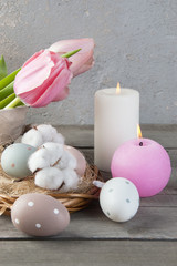 Eggs and aroma candles on old wooden background