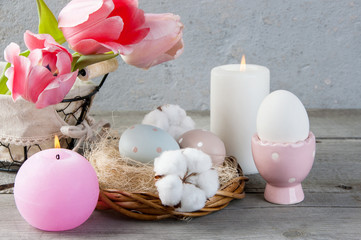 Eggs and aroma candles on old wooden background