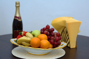 Holiday table view. Fruits, Champagne, napkins. Isolated, close up, interior.