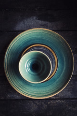 Craft maded empty plates and bowl on the wooden background
