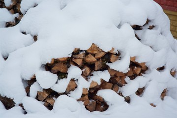 Split logs lie under the snow in the village