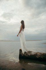 Girl in white dress on sea beach 