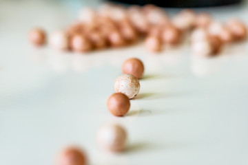 Close-up of face makeup pearls in gentle pink shades on a white background. Shallow depth of focus. Concept of beauty fashion.