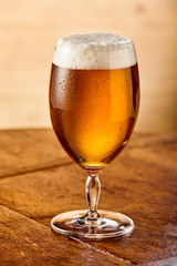 Chilled beer with a frothy head in a glass