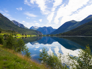 Naklejka na ściany i meble Vistas del paisaje de montaña reflejada en el lago Nedrefloen, en el verano de 2017 en Noruega