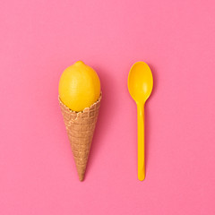 Ice Cream Cone with Lemon Fresh Fruit with spoon. Vegan Dessert Organic Food Concept. Flat lay. Trendy fashion Style. Minimal Design Art. Hot Summer Vibes. Sweet Pink Yellow Color.