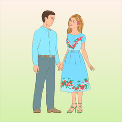 A young guy in trousers and a shirt stands with a girl in a blue dress. He holds her hand and lovingly looking at her.