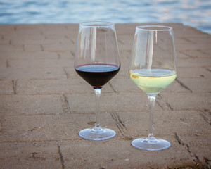 Two glasses of wine by lake