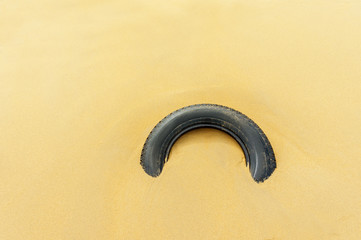 ecology wheel from the car lies in the sand