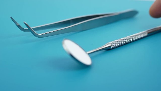 Professional Dentist tools in dental office: dentist mirror, forceps curved, explorer curved, dental explorer angular and explorer curved with chip, right. Dental Hygiene and Health conceptual image