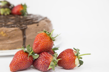 Pile of fresh strawberries isolated on white background with chocolate cake