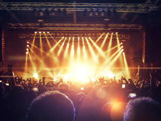 Concert hall crowded with people in front of a stage lit for the gig