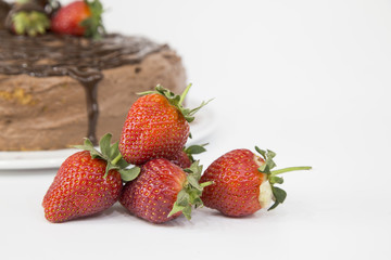 Pile of fresh strawberries isolated on white background with chocolate cake