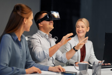 business, augmented reality and technology concept - developers with singapore city on virtual headset or 3d glasses screen working late at night office