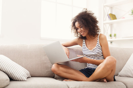 Young Girl With Laptop Sitting On Beige Couch
