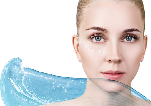 Woman with cream dots on face in blue water splash