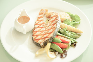 Grilled Salmon with salad on white plate.