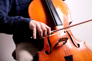 Man with cello in room with wall