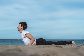 Fototapeta na wymiar Girl doing a yoga posture on the beach