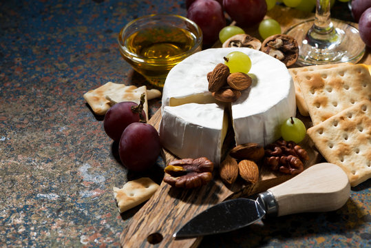 snacks and camembert cheese on a dark background