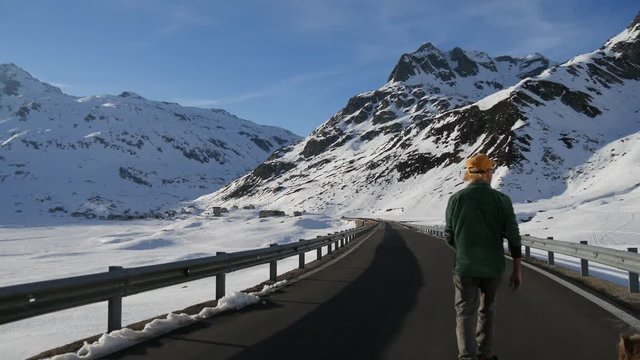 Turista con il cane su strada dello Spluga