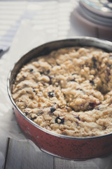Coffee cake in a tin pan on white wooden table. Vertical.