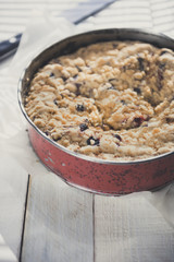 Coffee cake in a tin pan on white wooden table. Vertical. Copy space. 