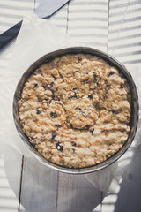 Coffee cake in a tin pan on white wooden table. Vertical.
