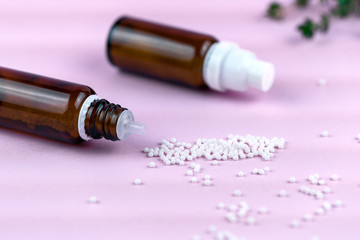 Homeopathic granules scattered on the Desk close to their glass containers.