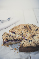 Tasty berries coffee cake on white wooden table. Vertical. Copy space. 