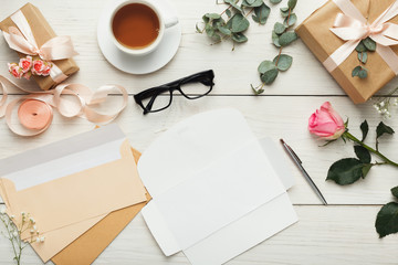 Wedding invitation cards and envelopes on white wooden table, to