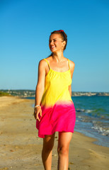 Fototapeta na wymiar smiling active woman on seashore in evening walking