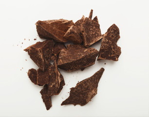 Heap of chocolate pieces isolated on white