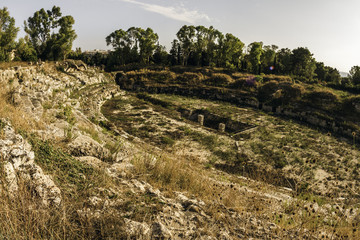 Fototapeta na wymiar Ruins of an old Greek amphitheater in Syracuse, Italy