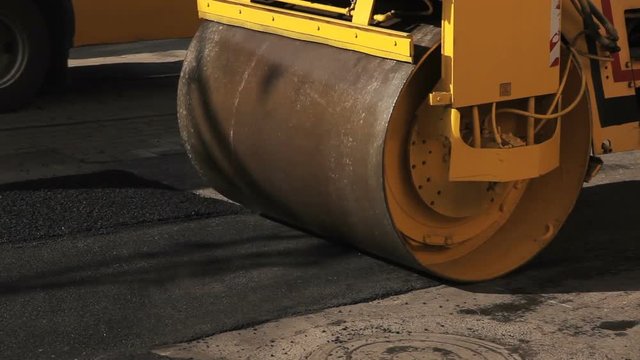 Road roller working on the new road construction site