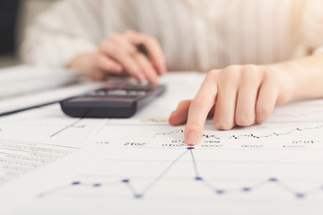 Closeup of woman hands working with documents and calculator