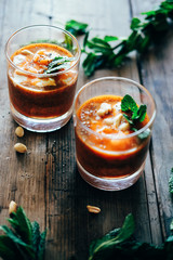 Cold and spicy carrot cream soup with peanuts, chia seeds and mint