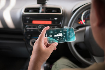 Hands of man using mobile smart phone vehicle analysis appiication in the car for mobile technology application concept
