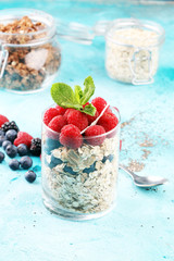 healthy breakfast with natural yogurt, muesli and berries on blue background