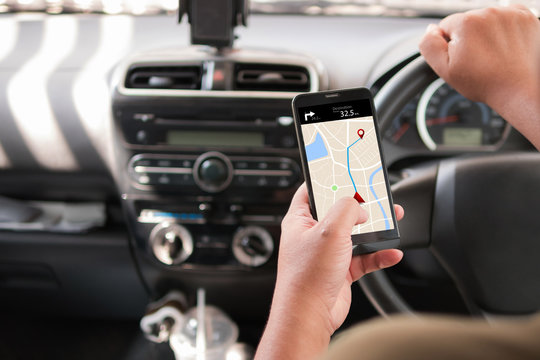 Hands of man using mobile smart phone with gps application in the car for mobile technology concept