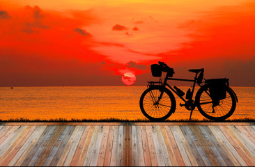 Fototapeta premium Empty top wooden table on sunrise and vintage bike background.