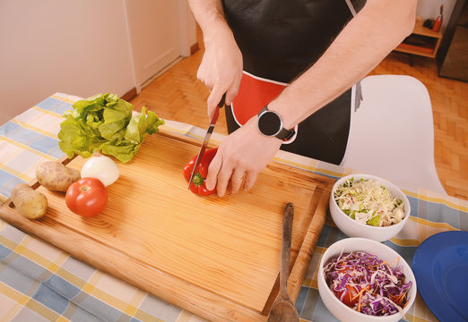 Close up of man cutting vegetables on the board