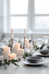 Wedding or festive table setting. Plates, wine glasses, candles and cutlery