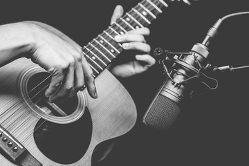 condenser microphone recording acoustic guitar sound in music studio