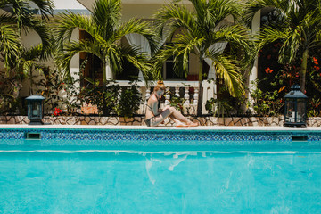 Eine junge Frau erholt sich am Pool 