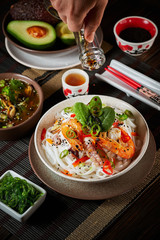 Preparation of rice noodles with fried shrimp and seafood. Soy sauce dressing