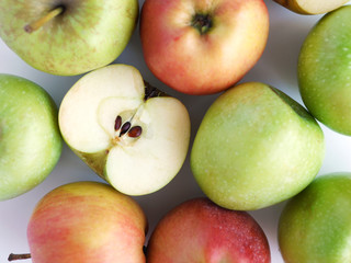 Green and red apples isolated on white background, top view, flat layout.