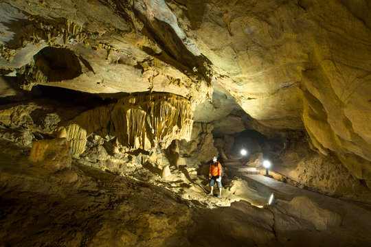 Man exploring beautiful cave at Nguom ngao cave near Ban Gioc waterfalls , Cao bang - North of Vietnam.